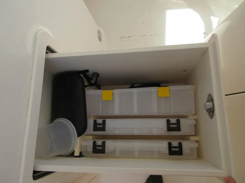Slide: The Image of Storage compartment in 2016 Grady-White Freedom 307 boat with organized containers. - 13
