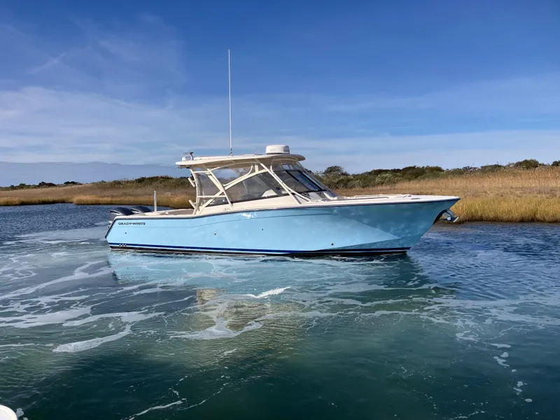 Slide: The Image of 2016 Grady-White Freedom 307 boat on calm water, clear sky background. - 3