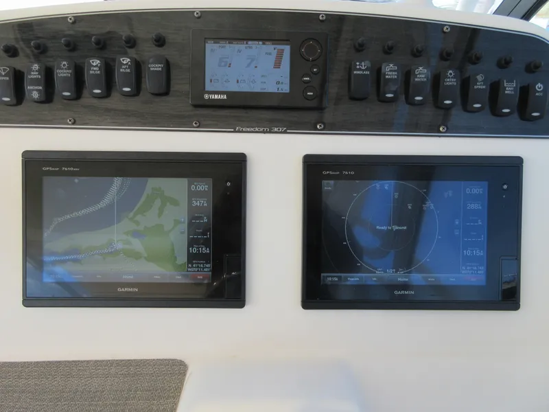 Slide: The Image of 2016 Grady-White Freedom 307 dashboard with Garmin navigation displays and controls. - 31
