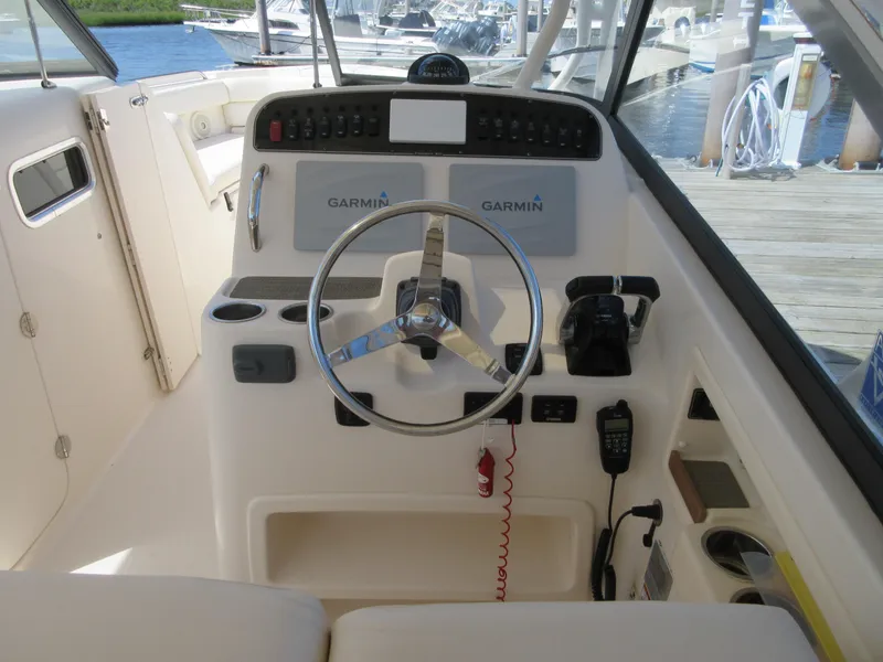 Slide: The Image of 2016 Grady-White Freedom 307 boat helm with Garmin electronics and steering wheel. - 8
