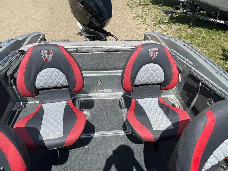 Slide: The Image of 2022 Triton 206 Allure boat interior with red and black seats. - 11