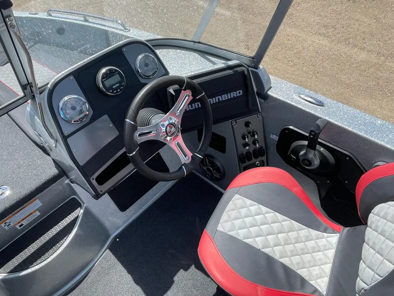 Slide: The Image of 2022 Triton 206 Allure boat dashboard with steering wheel and red-gray seat. - 20