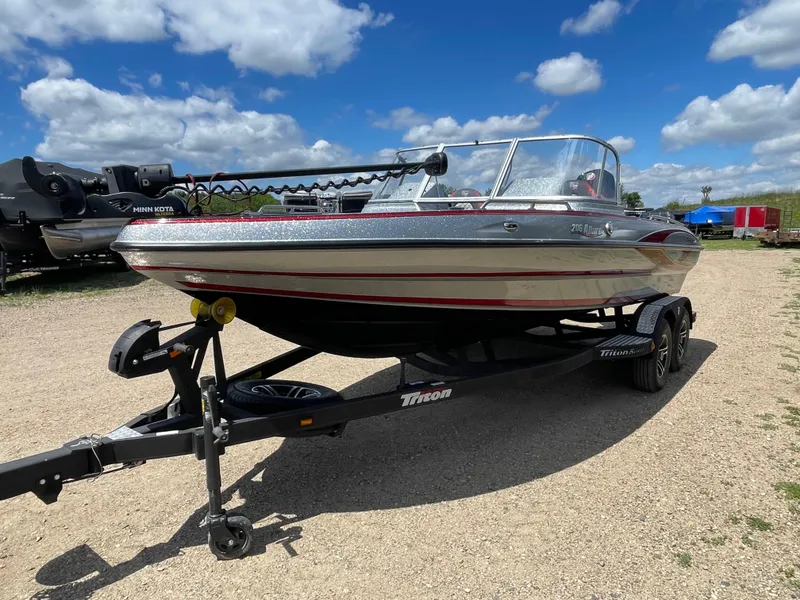 Slide: The Image of 2022 Triton 206 Allure boat on a trailer under a blue sky. - 5