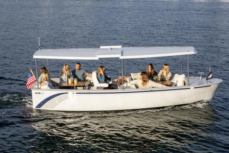 The Image of 2026 Duffy Balboa 20' boat cruising with passengers on a sunny day. - 0