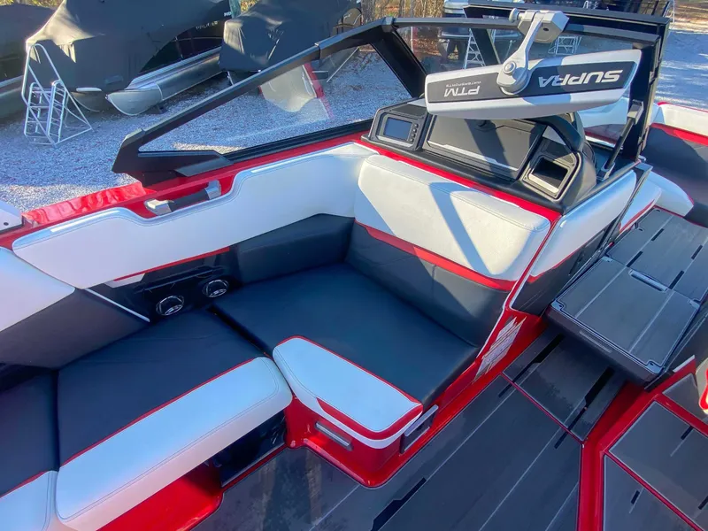 Slide: The Image of Interior of a 2024 Supra SE boat with red and white seating. - 17