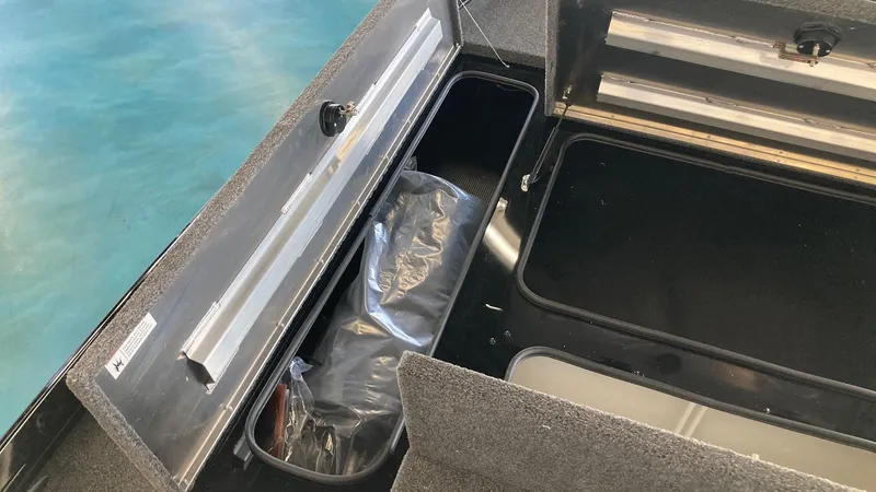Slide: The Image of 2024 Crestliner XFC 189 boat storage compartments with open lids, showcasing interior space. - 13