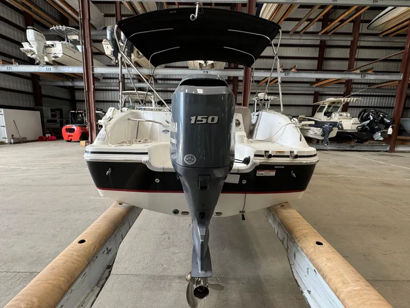 Slide: The Image of 2014 Hurricane SunDeck Sport 202 OB boat with 150 HP engine in storage facility. - 13