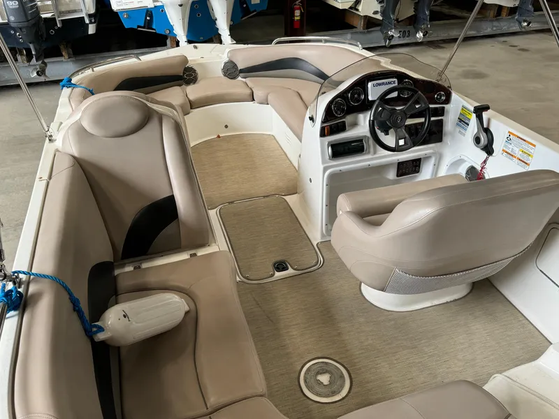 Slide: The Image of 2014 Hurricane SunDeck Sport 202 OB boat interior with beige seating and steering console. - 4