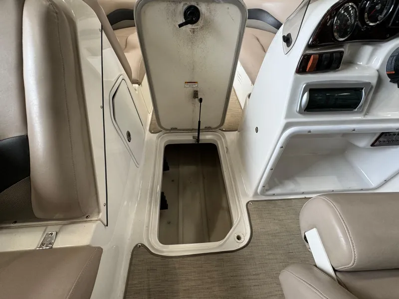 Slide: The Image of 2014 Hurricane SunDeck Sport 202 OB interior with open storage compartment and dashboard view. - 8