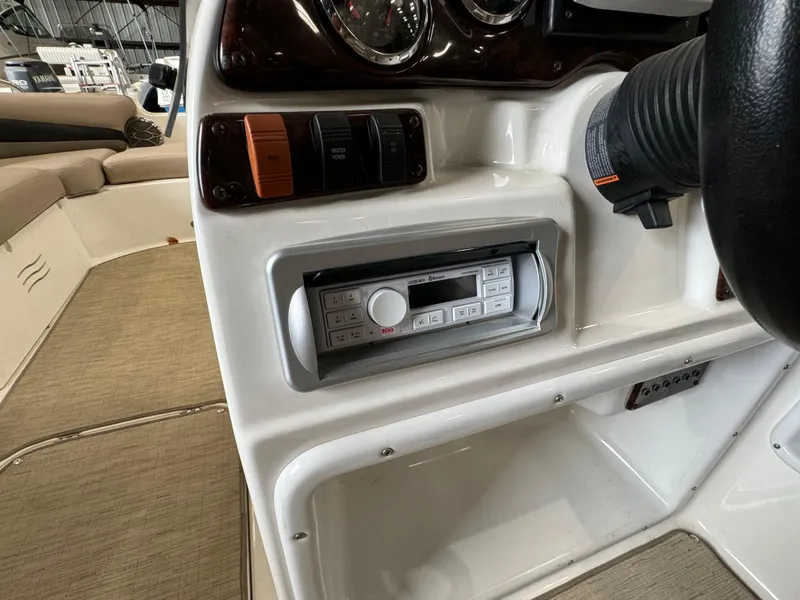 Slide: The Image of 2014 Hurricane SunDeck Sport 202 OB boat dashboard with stereo system and controls. - 9