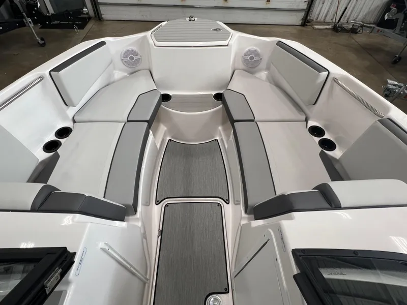 Slide: The Image of 2024 Yamaha Boats AR220 interior with gray and white seating, cup holders, and speakers. - 5