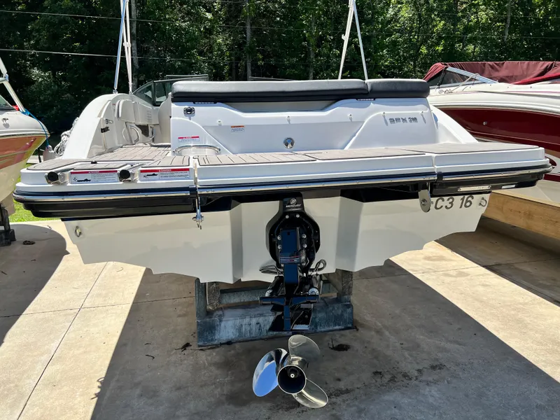Slide: The Image of 2023 Sea Ray SPX 210 boat rear view with outboard motor, docked outdoors. - 13