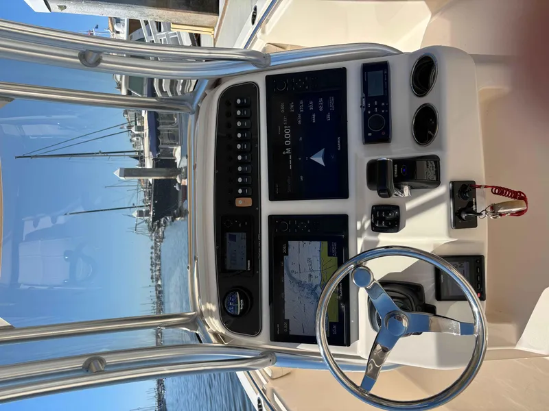 Slide: The Image of 2018 Grady-White Fisherman 216 boat dashboard with navigation controls and steering wheel. - 6