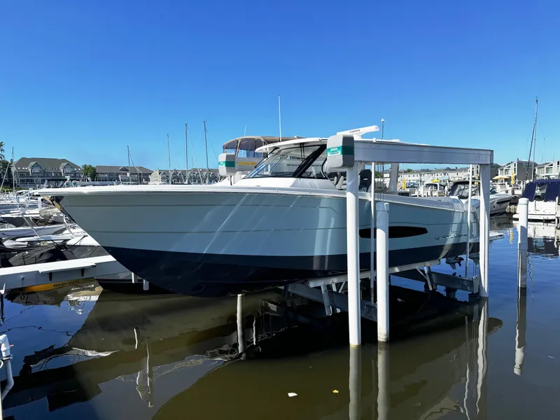 Slide: The Image of 2025 Regal 38 SAV boat docked at a marina on a sunny day. - 0