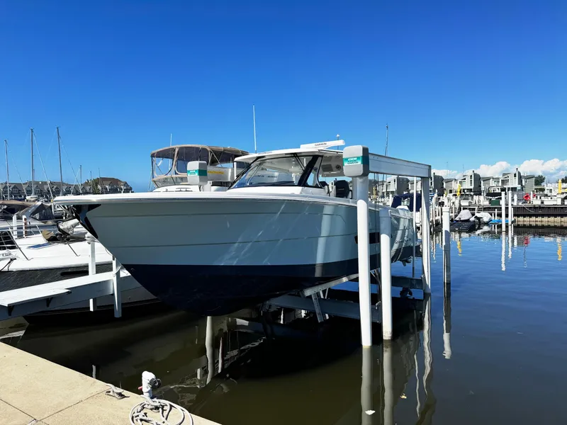 Slide: The Image of 2025 Regal 38 SAV boat docked at a marina on a sunny day. - 1
