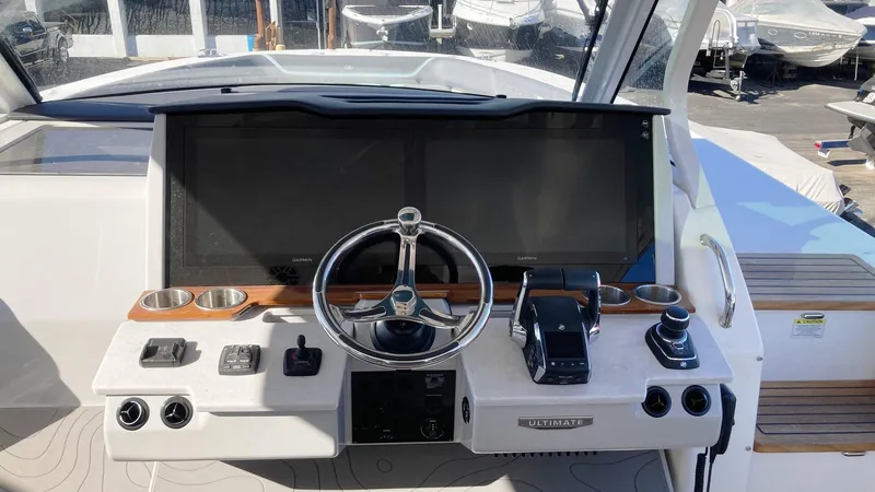 Slide: The Image of 2025 Regal 38 SAV boat helm with modern controls and steering wheel. - 14