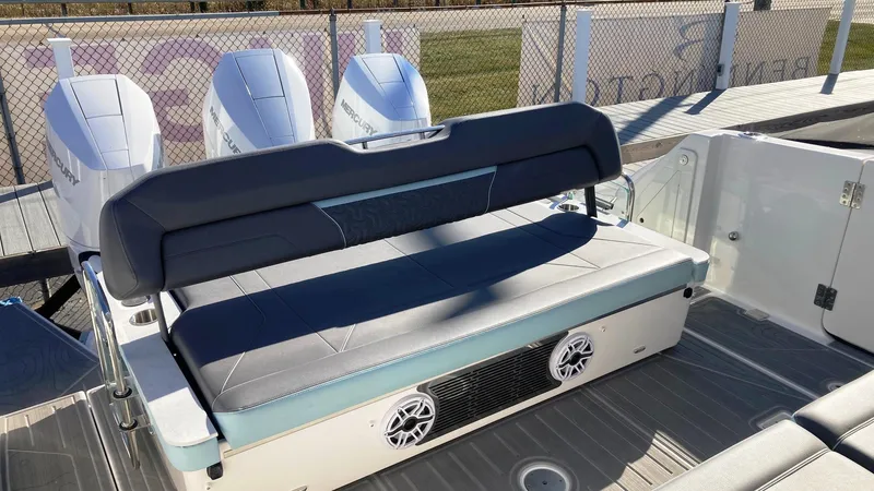 Slide: The Image of 2025 Regal 38 SAV boat with cushioned seating and powerful outboard engines. - 15