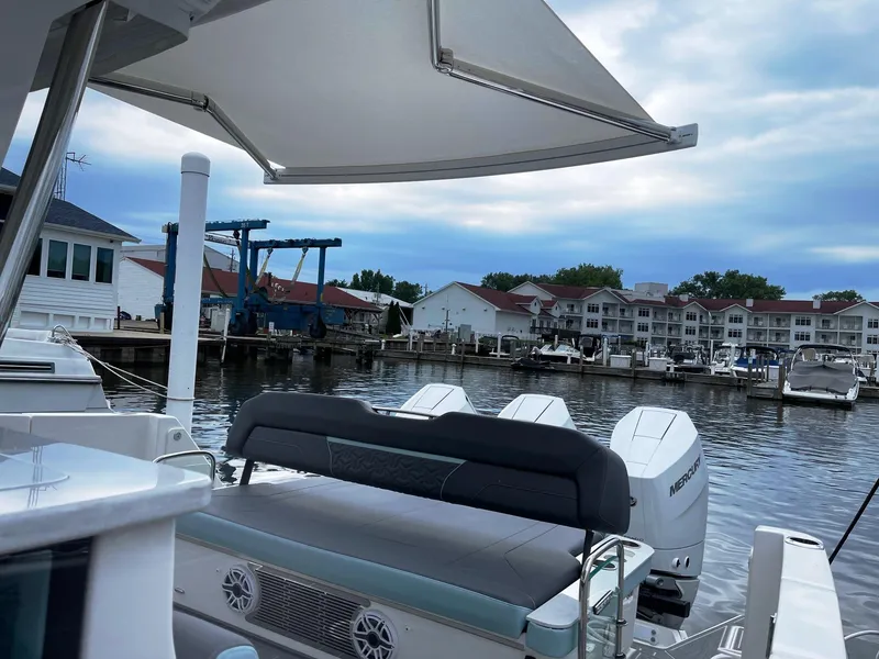 Slide: The Image of 2025 Regal 38 SAV boat docked at a marina with waterfront buildings in the background. - 17