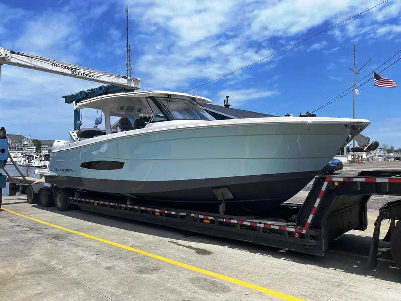Slide: The Image of 2025 Regal 38 SAV boat on a trailer at a marina. - 3