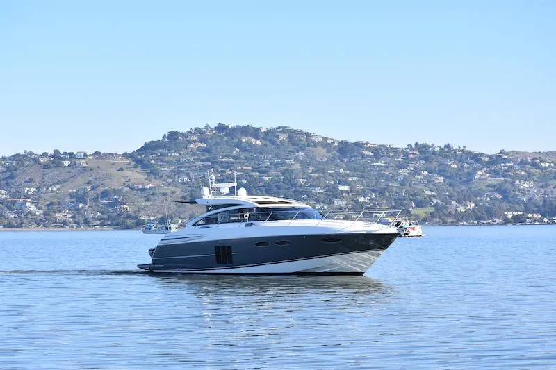 Slide: The Image of 2013 Princess V52 yacht cruising on a calm lake with hills in the background. - 0