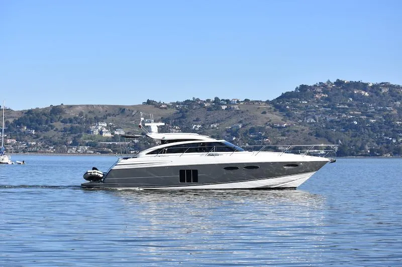 Slide: The Image of 2013 Princess V52 yacht cruising on a calm lake with scenic hills in the background. - 1