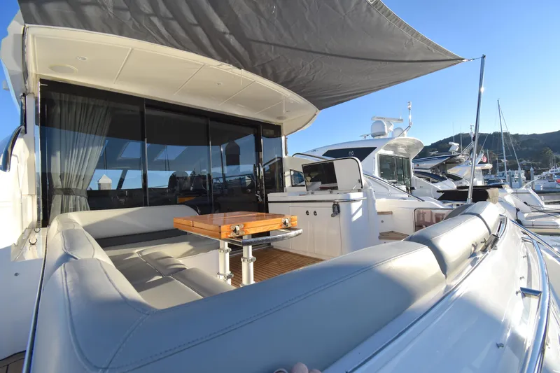Slide: The Image of 2013 Princess V52 yacht with shaded deck and seating area in marina. - 15
