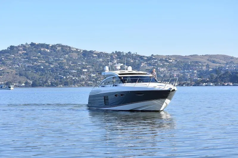 Slide: The Image of 2013 Princess V52 yacht cruising on a calm lake with hills in the background. - 3