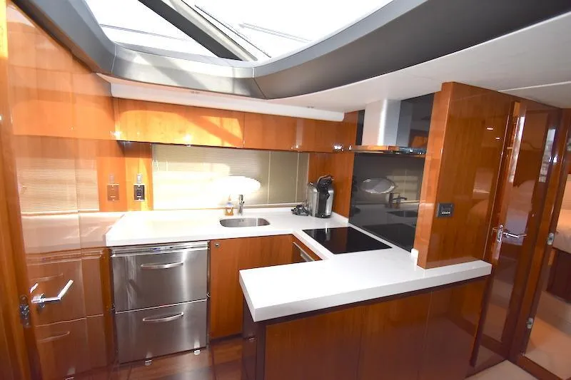 Slide: The Image of Modern kitchen in a 2013 Princess V52 yacht with sleek wood cabinetry and stainless steel appliances. - 31