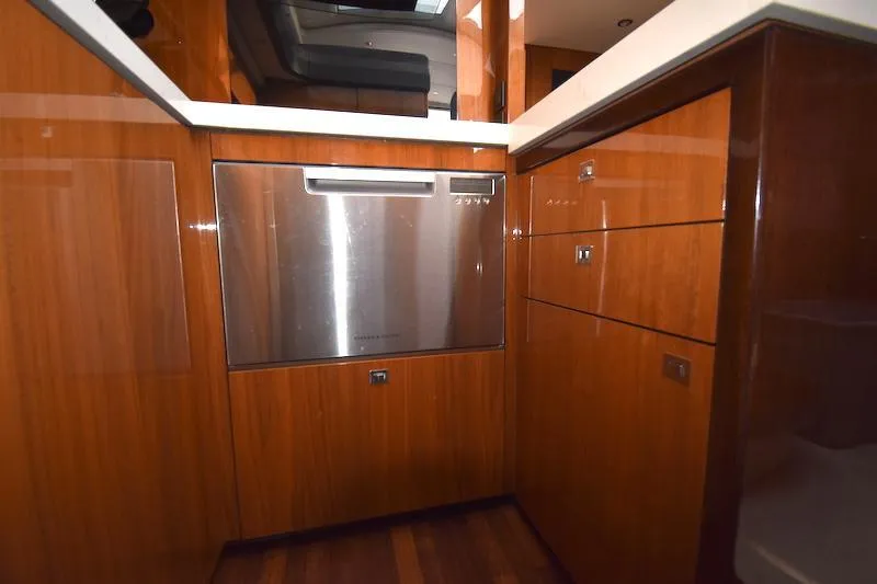 Slide: The Image of Modern kitchen area in a 2013 Princess V52 yacht with wood cabinetry and stainless steel appliances. - 33