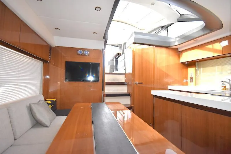Slide: The Image of Interior of 2013 Princess V52 yacht with modern wood finishes and a cozy seating area. - 35