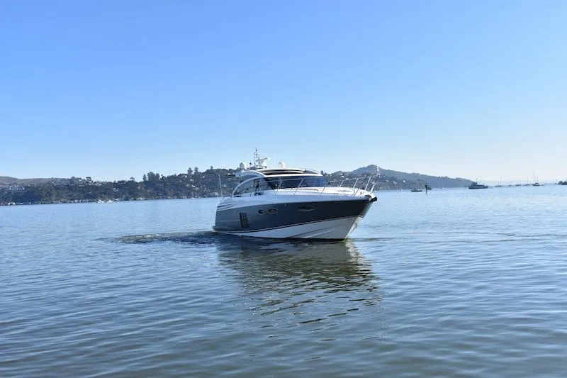 Slide: The Image of 2013 Princess V52 yacht cruising on calm waters with scenic background. - 4