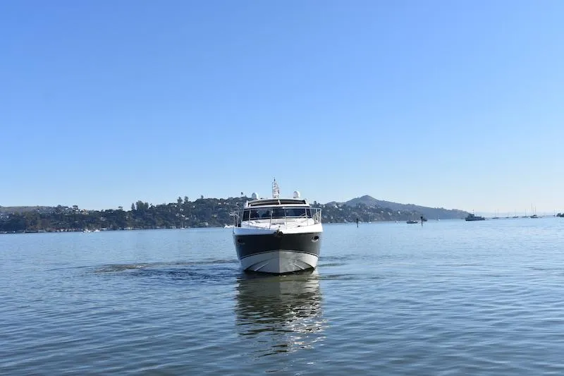 Slide: The Image of 2013 Princess V52 yacht cruising on a calm sea with a scenic coastal backdrop. - 5
