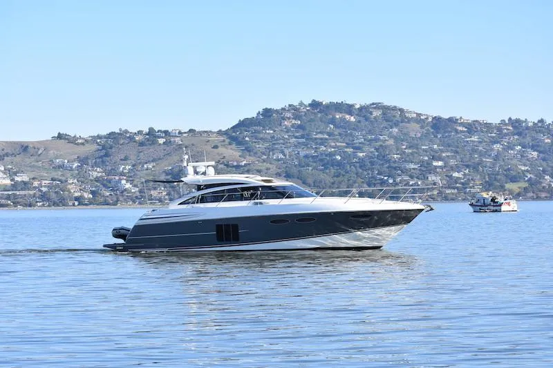 Slide: The Image of 2013 Princess V52 yacht cruising on a calm lake with hills in the background. - 67