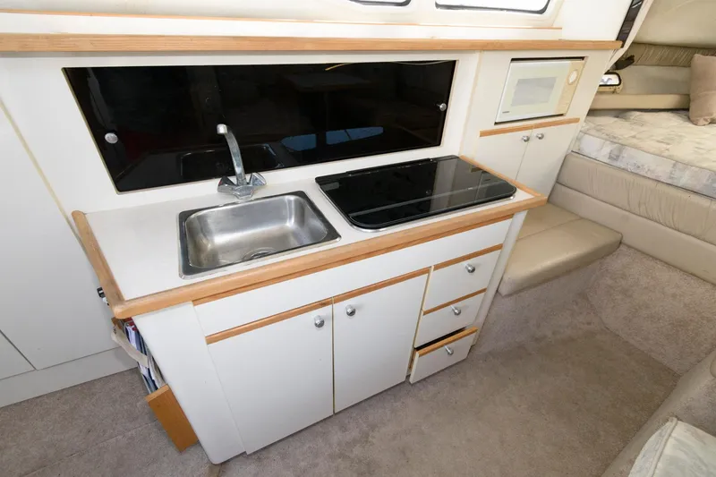 Slide: The Image of 1998 Bayliner 2855 Ciera galley with sink, stove, and microwave. - 7