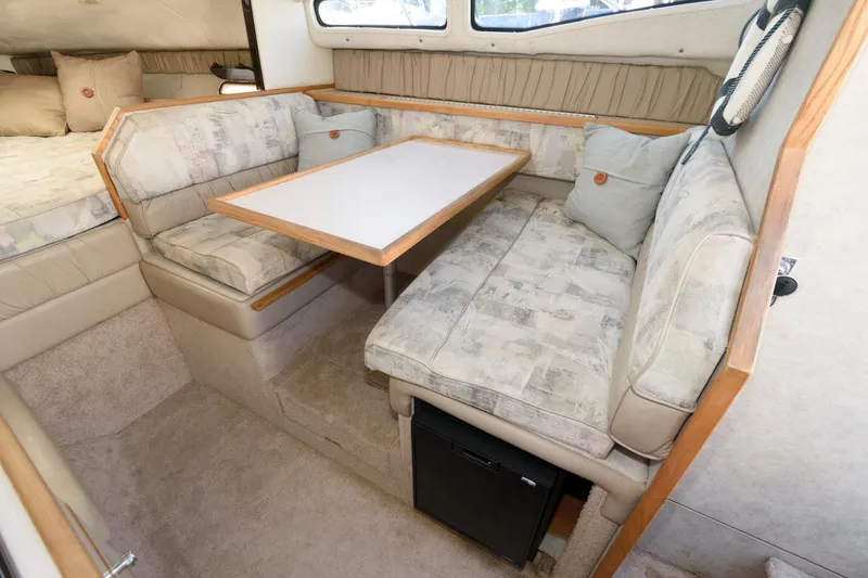 Slide: The Image of 1998 Bayliner 2855 Ciera cabin interior with dining area and cushioned seating. - 8