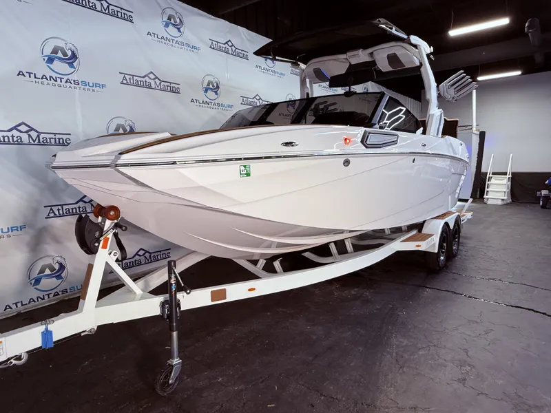 Slide: The Image of 2024 Supra SL 400 boat on trailer in showroom. - 12