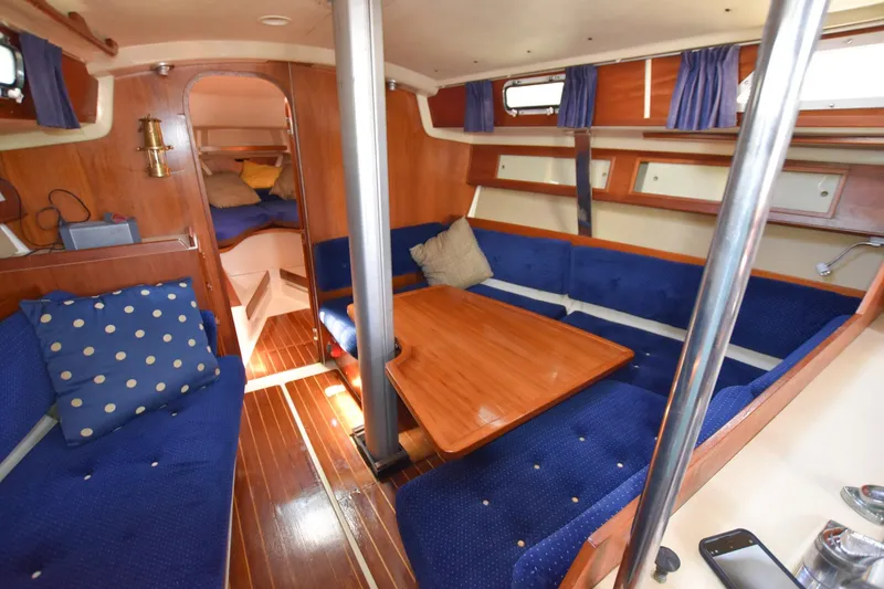 Slide: The Image of Interior of 1985 Pearson 36-2 sailboat with blue seating and wooden table. - 18