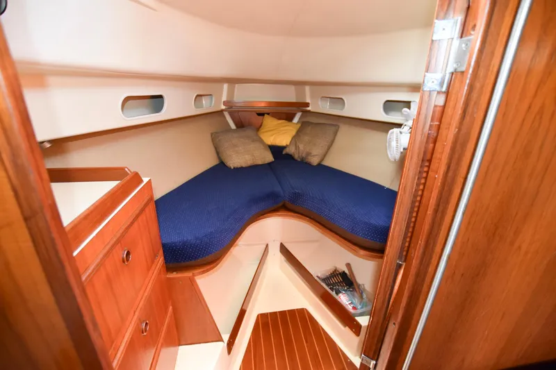 Slide: The Image of 1985 Pearson 36-2 sailboat interior cabin with blue bedding and wooden cabinetry. - 22
