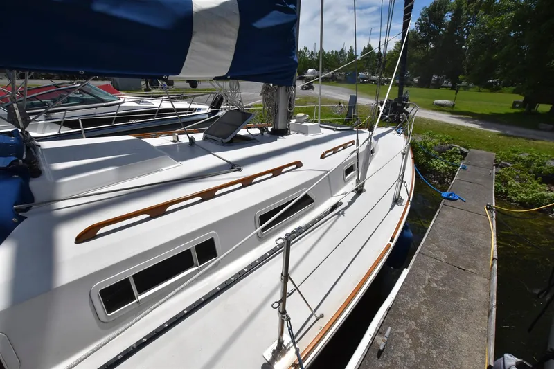 Slide: The Image of 1985 Pearson 36-2 sailboat docked, showcasing deck and cabin windows. - 5