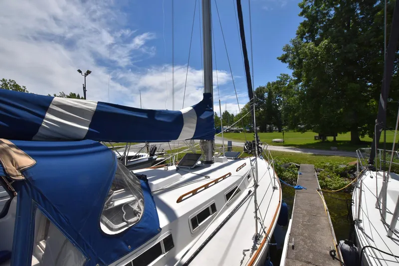 Slide: The Image of 1985 Pearson 36-2 sailboat docked, featuring blue and white sail covers. - 7
