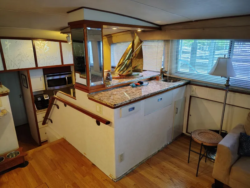 Slide: The Image of Interior of a 1976 Bertram 58 Flybridge Motor Yacht with wood flooring and granite countertops. - 10