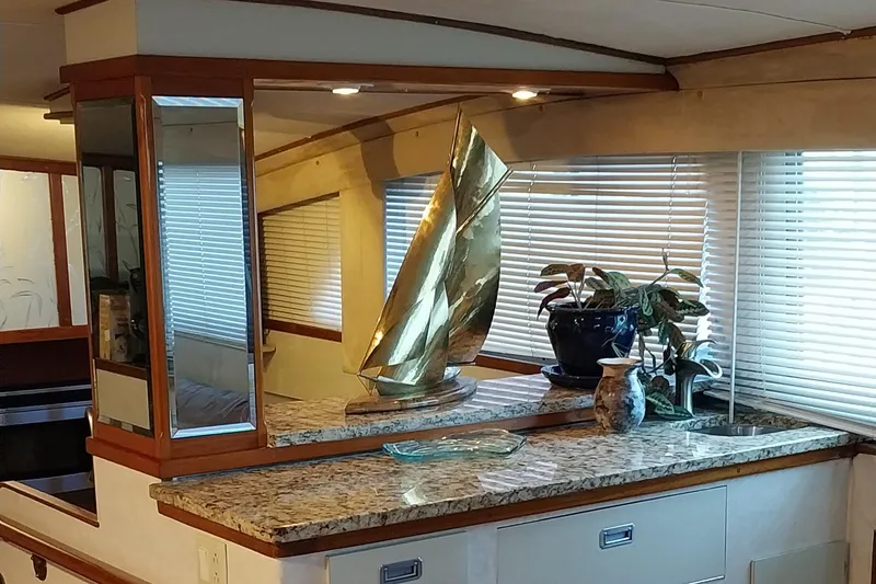 Slide: The Image of 1976 Bertram 58 Flybridge Motor Yacht interior with granite countertop and decorative items. - 11