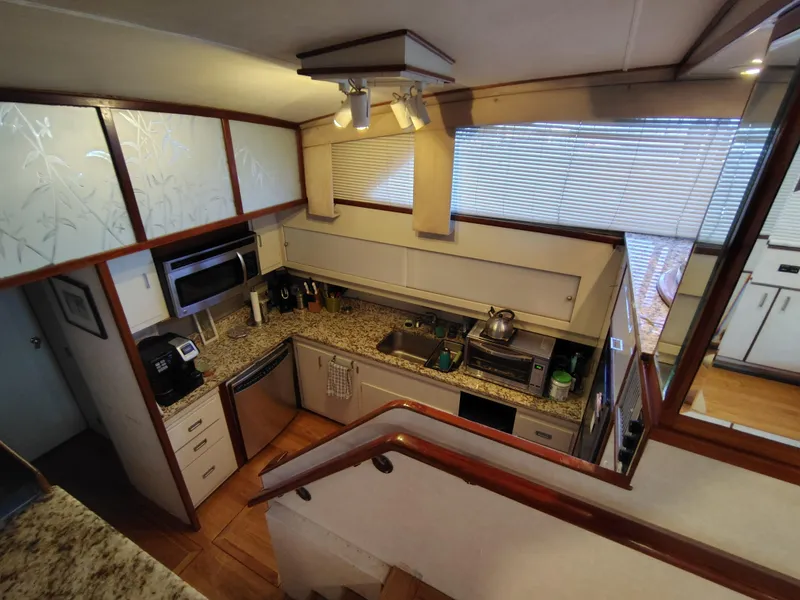 Slide: The Image of 1976 Bertram 58 Flybridge Motor Yacht kitchen with modern appliances and granite countertops. - 13