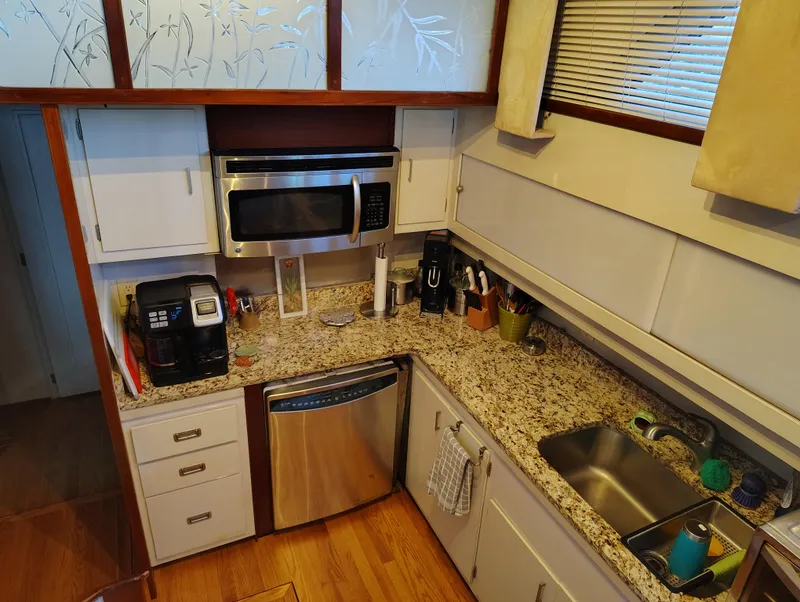 Slide: The Image of 1976 Bertram 58 Flybridge Motor Yacht kitchen with granite countertops and modern appliances. - 15