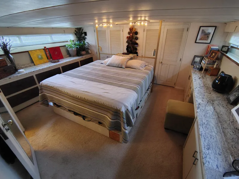 Slide: The Image of Interior of 1976 Bertram 58 Flybridge Motor Yacht bedroom with cozy decor and ample storage. - 2