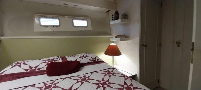 Slide: The Image of 1976 Bertram 58 Flybridge Motor Yacht bedroom with quilted bedspread and porthole windows. - 20