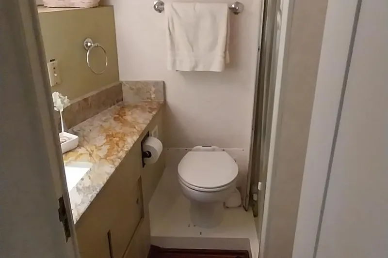 Slide: The Image of 1976 Bertram 58 Flybridge Motor Yacht bathroom with marble countertop and towel rack. - 22