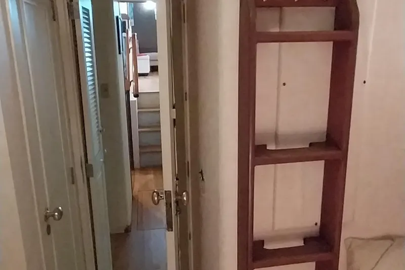 Slide: The Image of Interior hallway of a 1976 Bertram 58 Flybridge Motor Yacht with wooden shelving. - 26