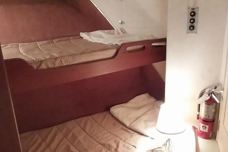 Slide: The Image of 1976 Bertram 58 Flybridge Motor Yacht cabin with bunk beds and fire extinguisher. - 27
