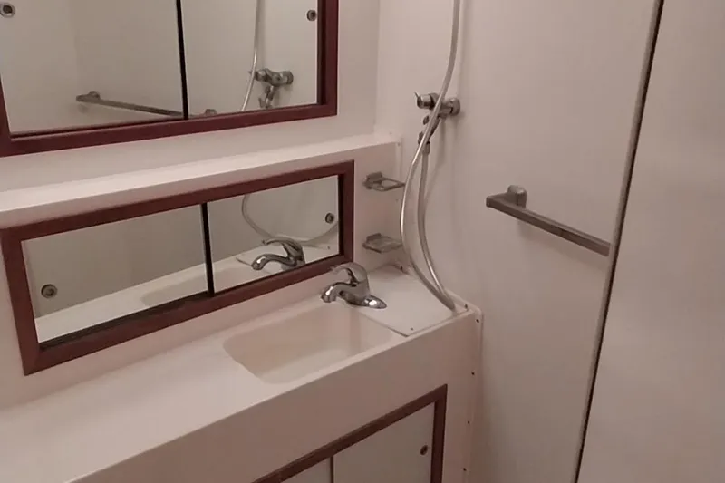 Slide: The Image of 1976 Bertram 58 Flybridge Motor Yacht bathroom with sink, mirror, and shower. - 31